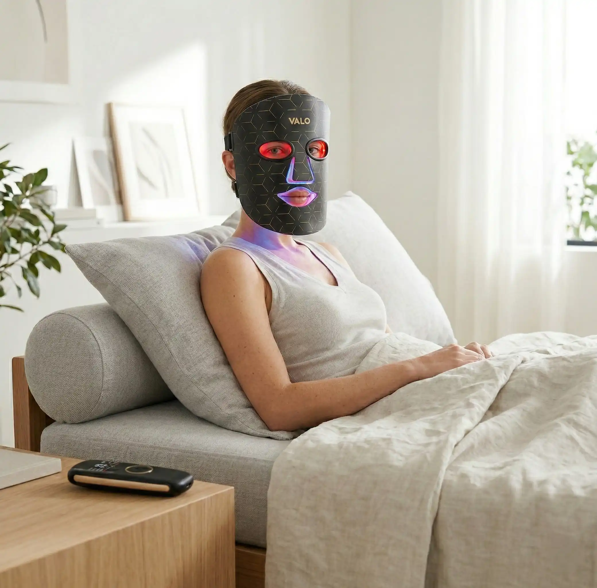 Woman relaxing at home using the Valo Glow LED face mask for her evening skincare routine
