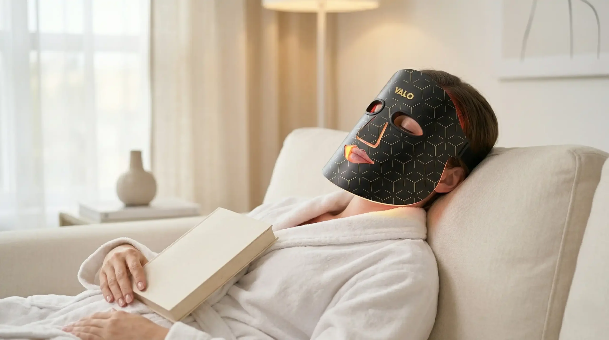 Woman relaxing at home wearing Valo Glow LED face mask during evening skincare routine